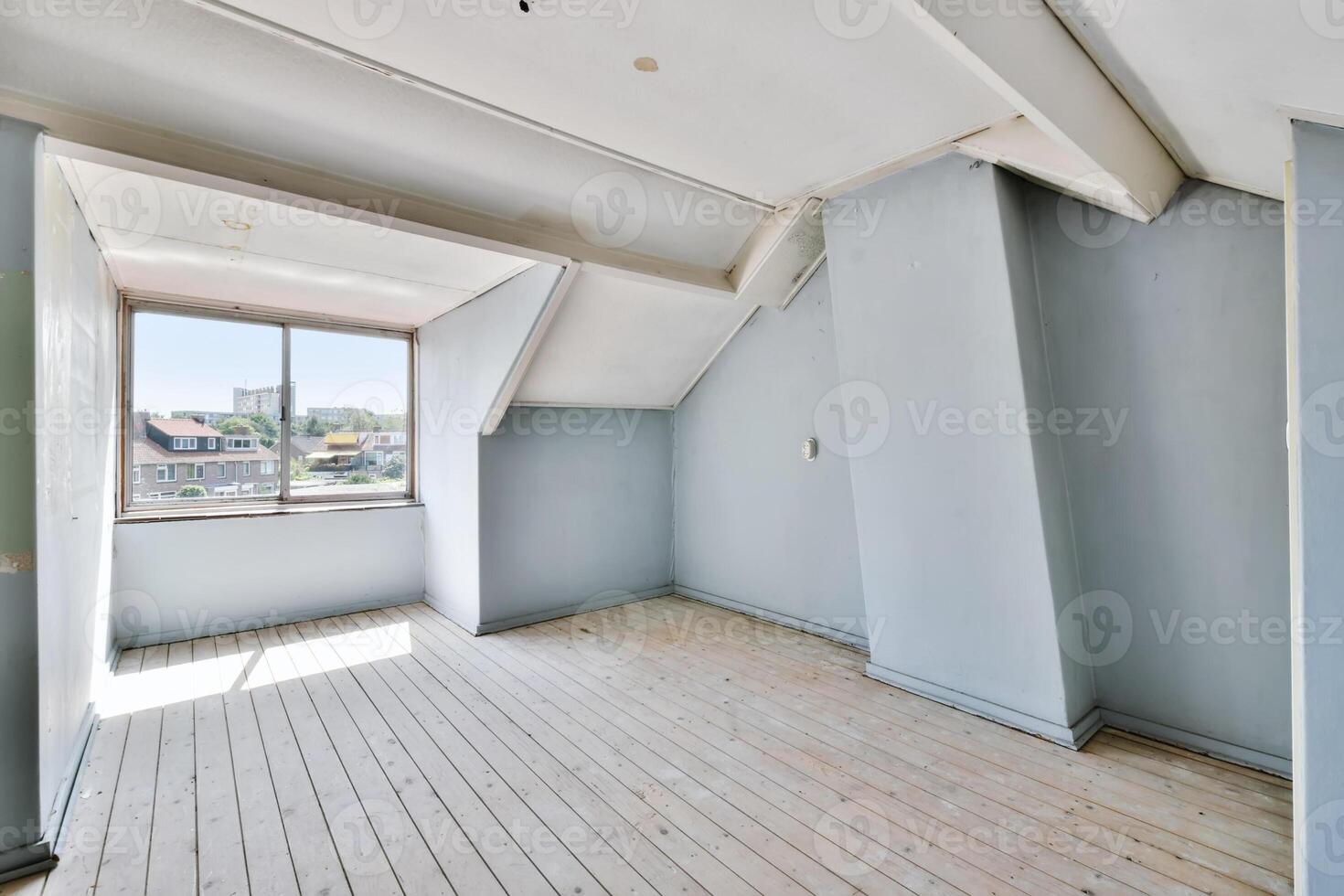 An empty room with a window and a wooden floor photo