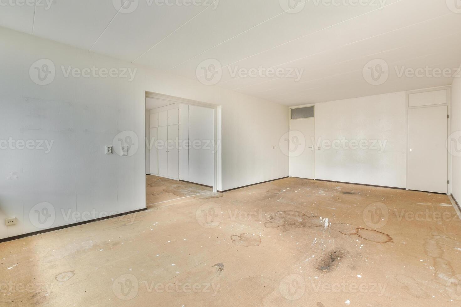 An empty room with a white ceiling and a door photo
