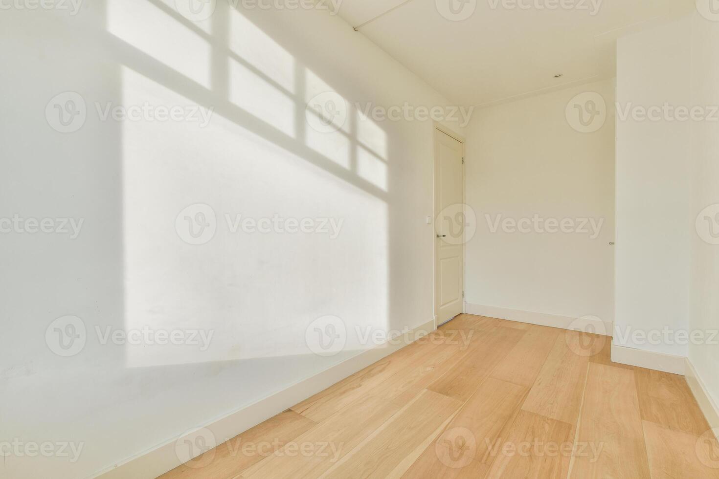 A white room with a wooden floor and a window photo