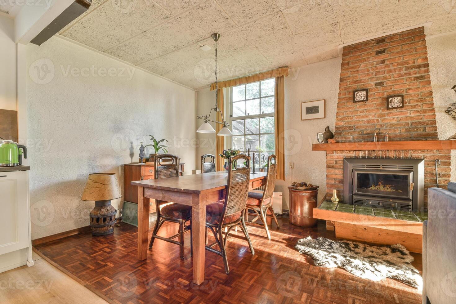 A kitchen with a table and chairs in front of a fireplace photo