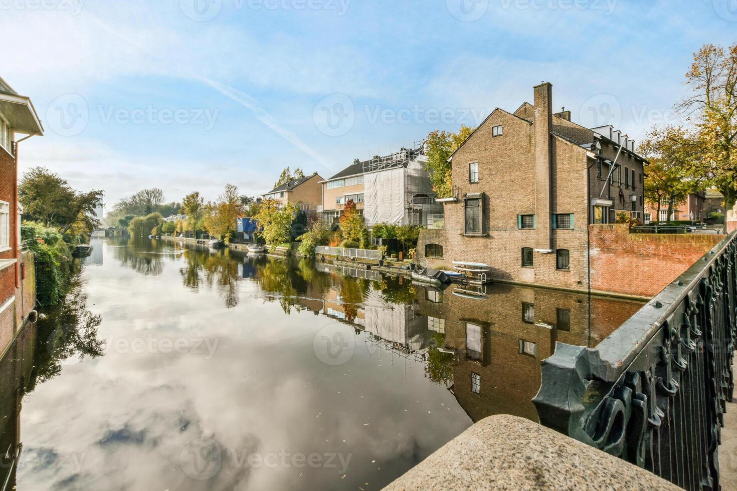 A canal in the middle of a city with buildings and trees photo