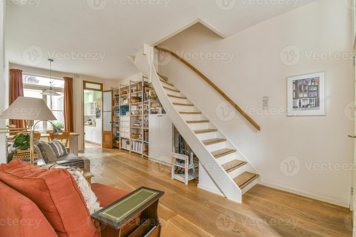 A living room with a staircase and bookshelves photo