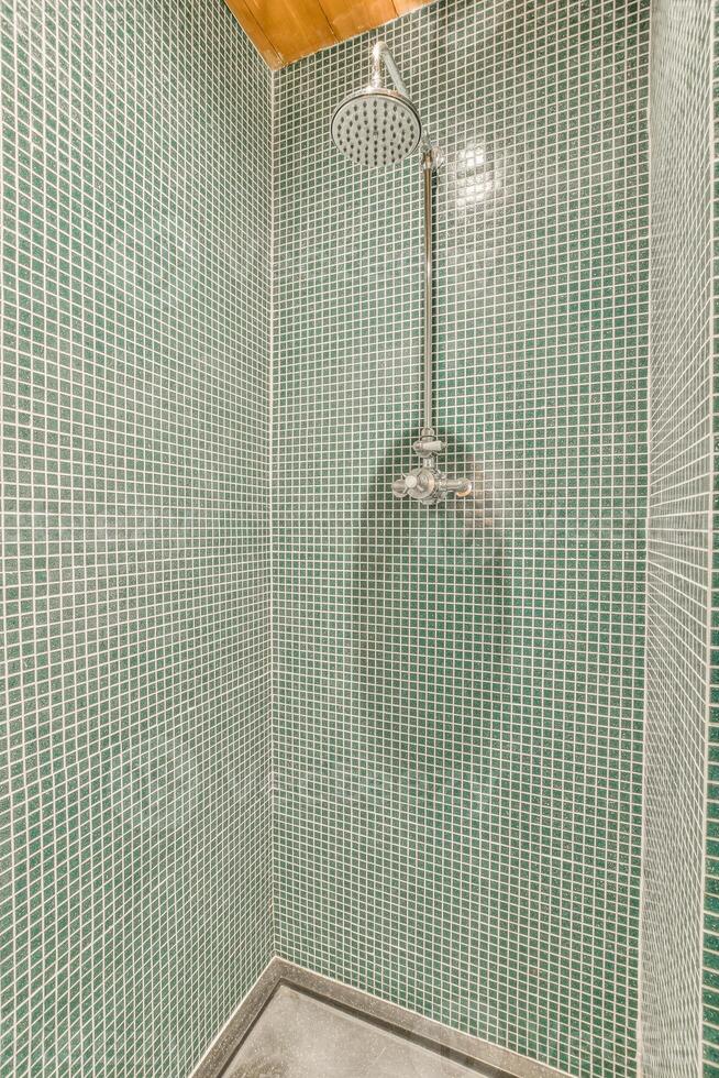 A shower with green tiles and a wooden ceiling photo