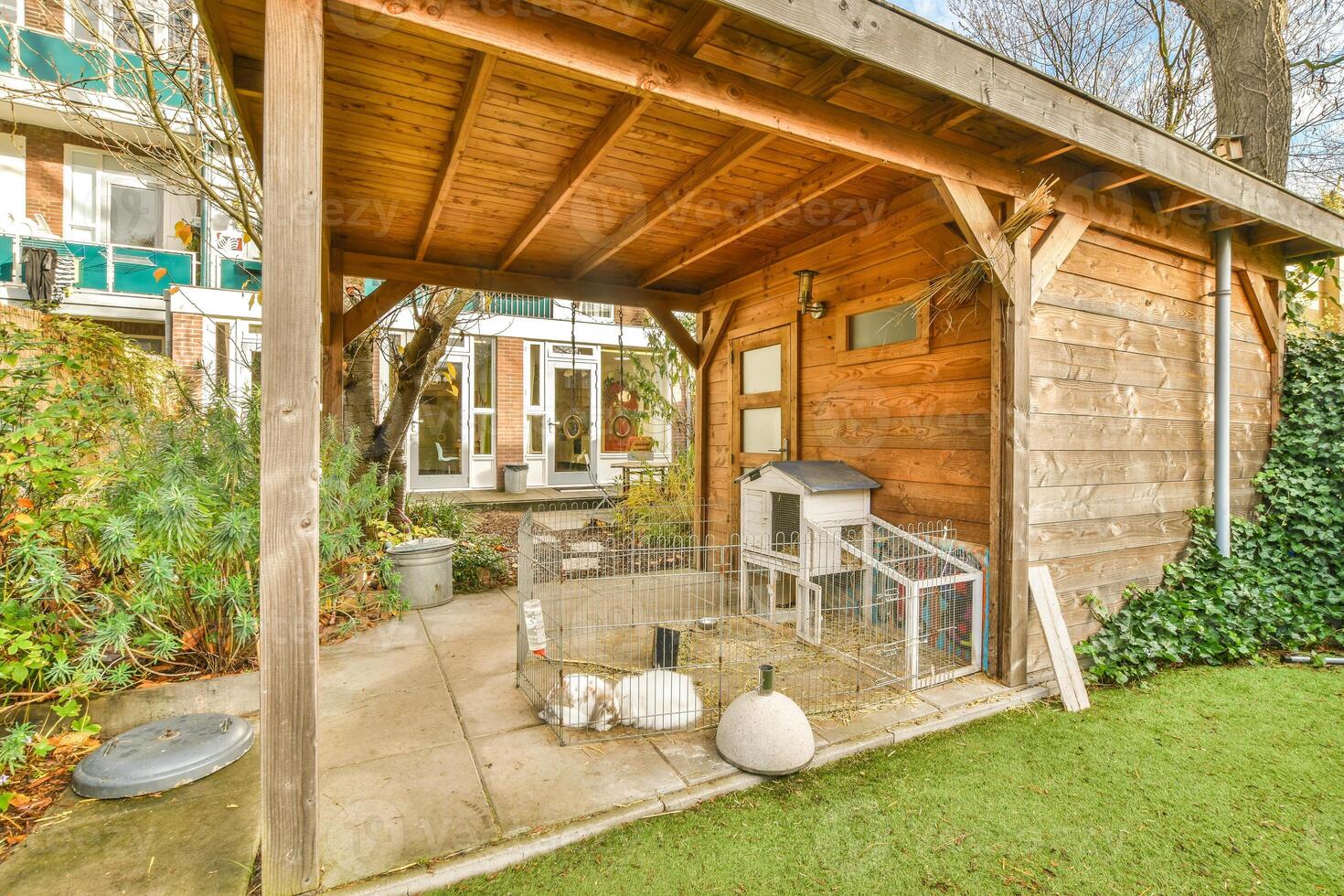 A small wooden house with a chicken coop in the backyard photo