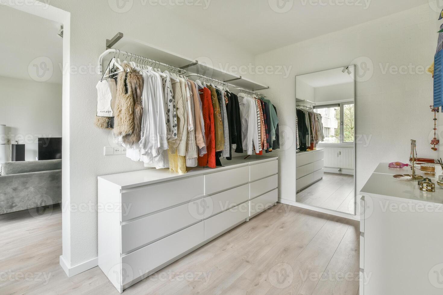 A walk in closet with clothes on the shelves photo