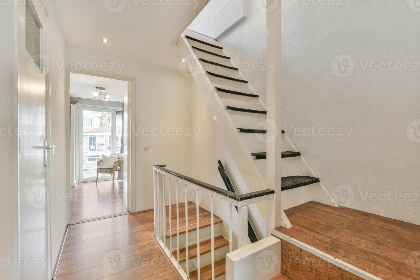 A white stair case with a wooden floor photo