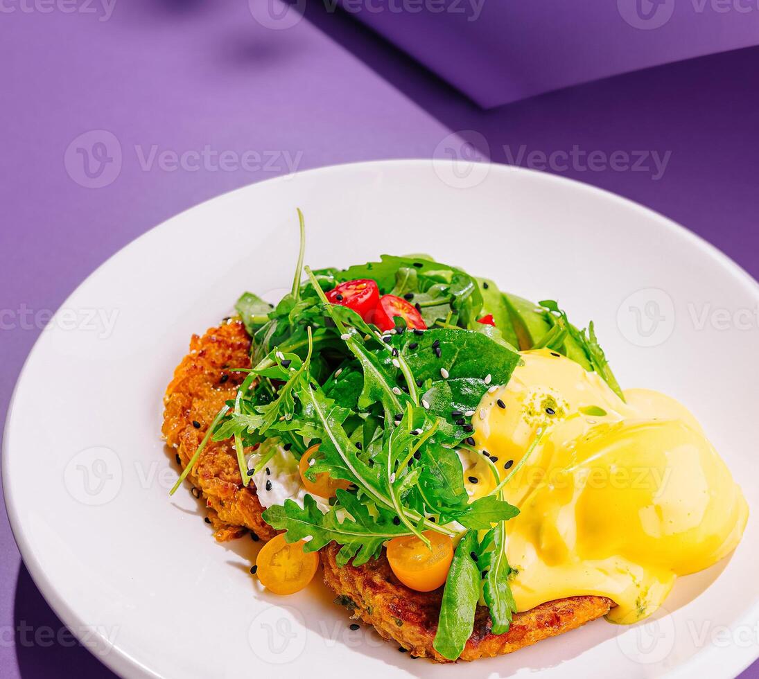 Delicious sweet potato pancakes being served with poached egg and greens photo