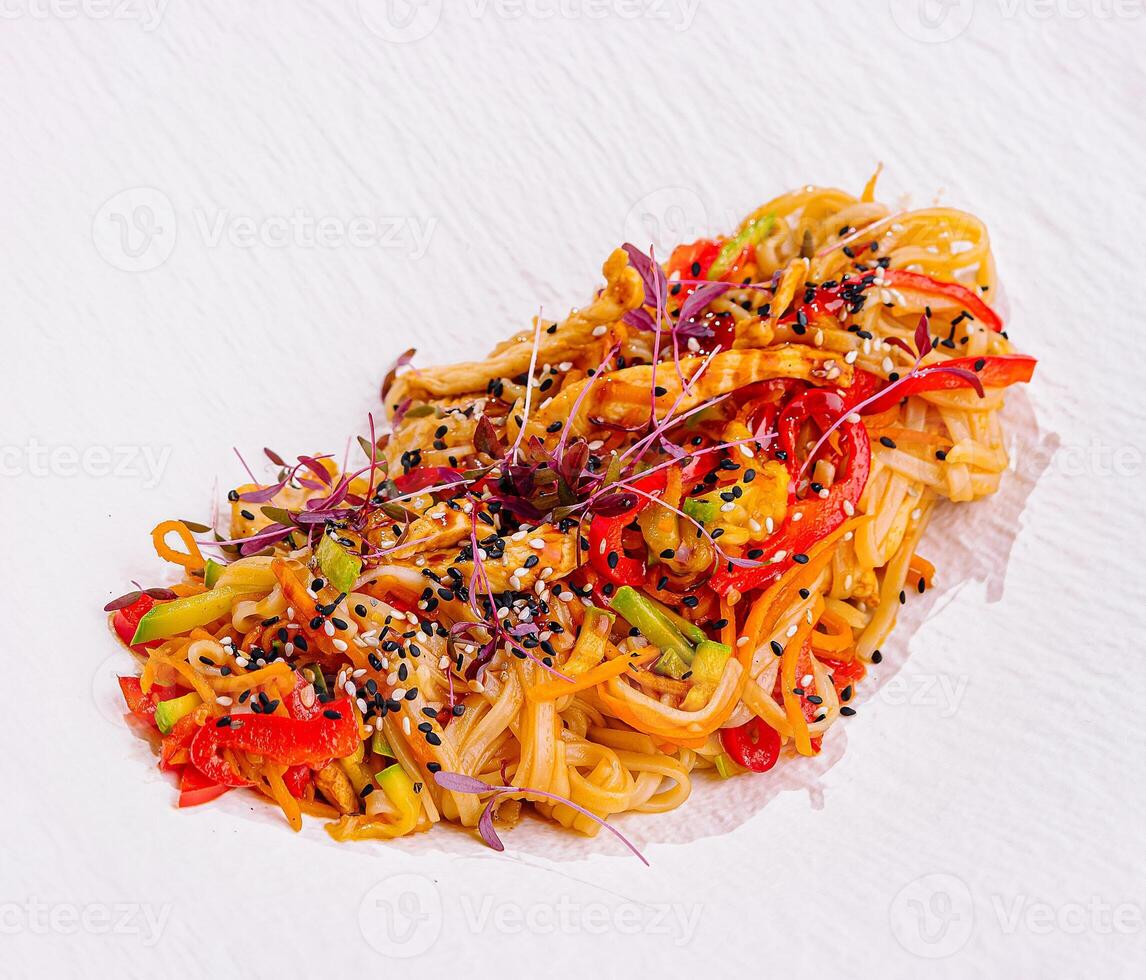Udon noodles with chicken and vegetables sprinkled with sesame seeds photo