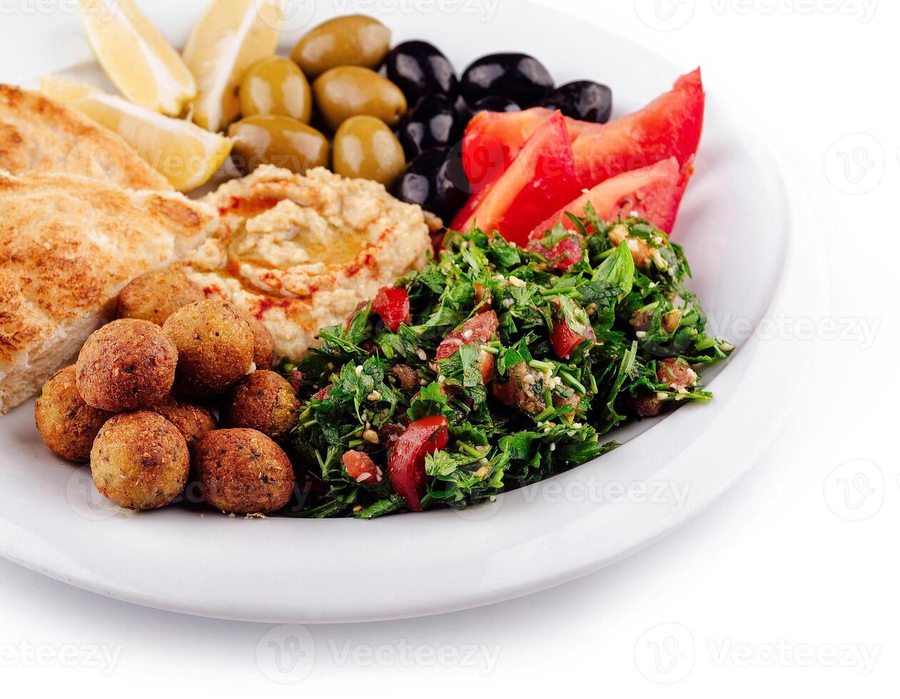Plate presenting a colorful and tasty middle eastern mezze platter with various dips and salads photo