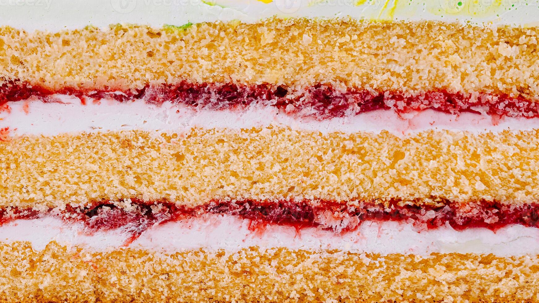 Delicious layered cake with cream filling and strawberry jam showing texture photo