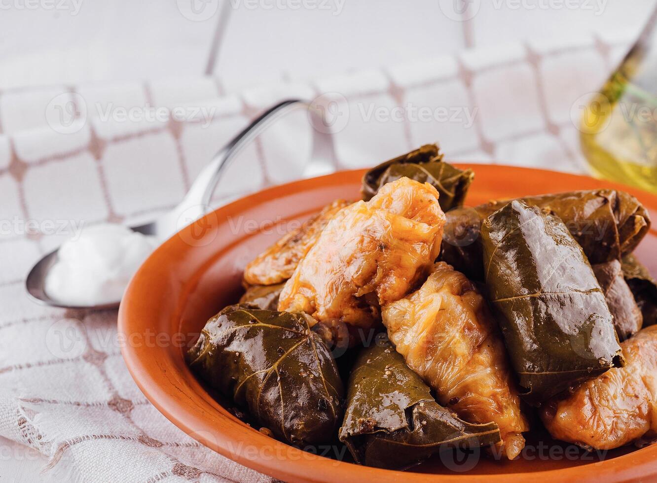 Traditional dolma stuffed grape leaves with rice and spices on rustic table setting photo
