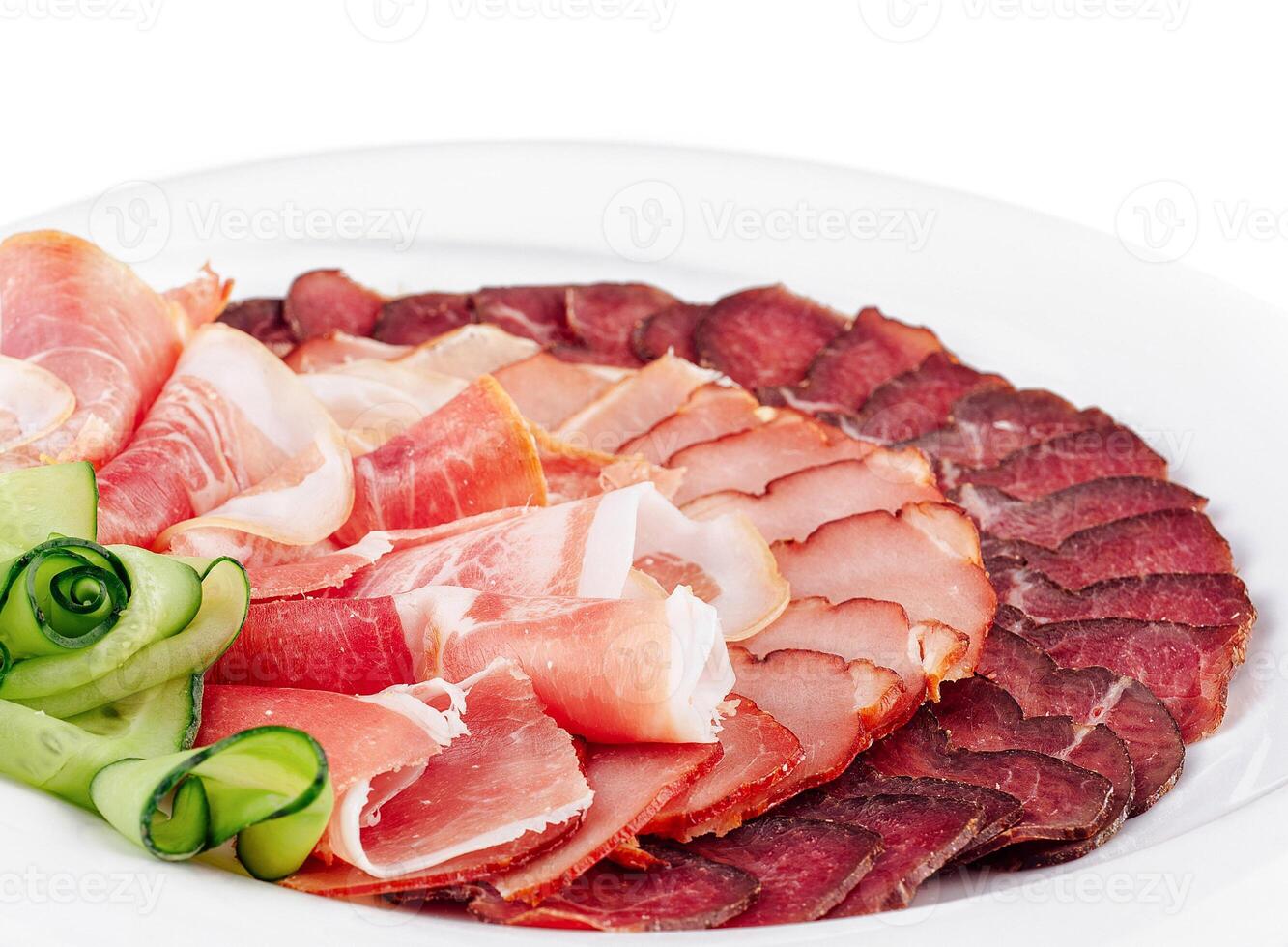 Plate presenting delicious cured meat slices with cucumber decoration photo