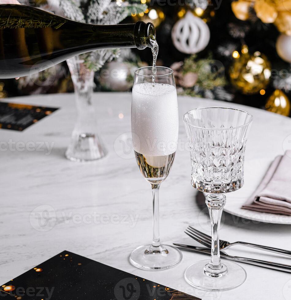 Champagne being poured into a flute glass with festive background photo