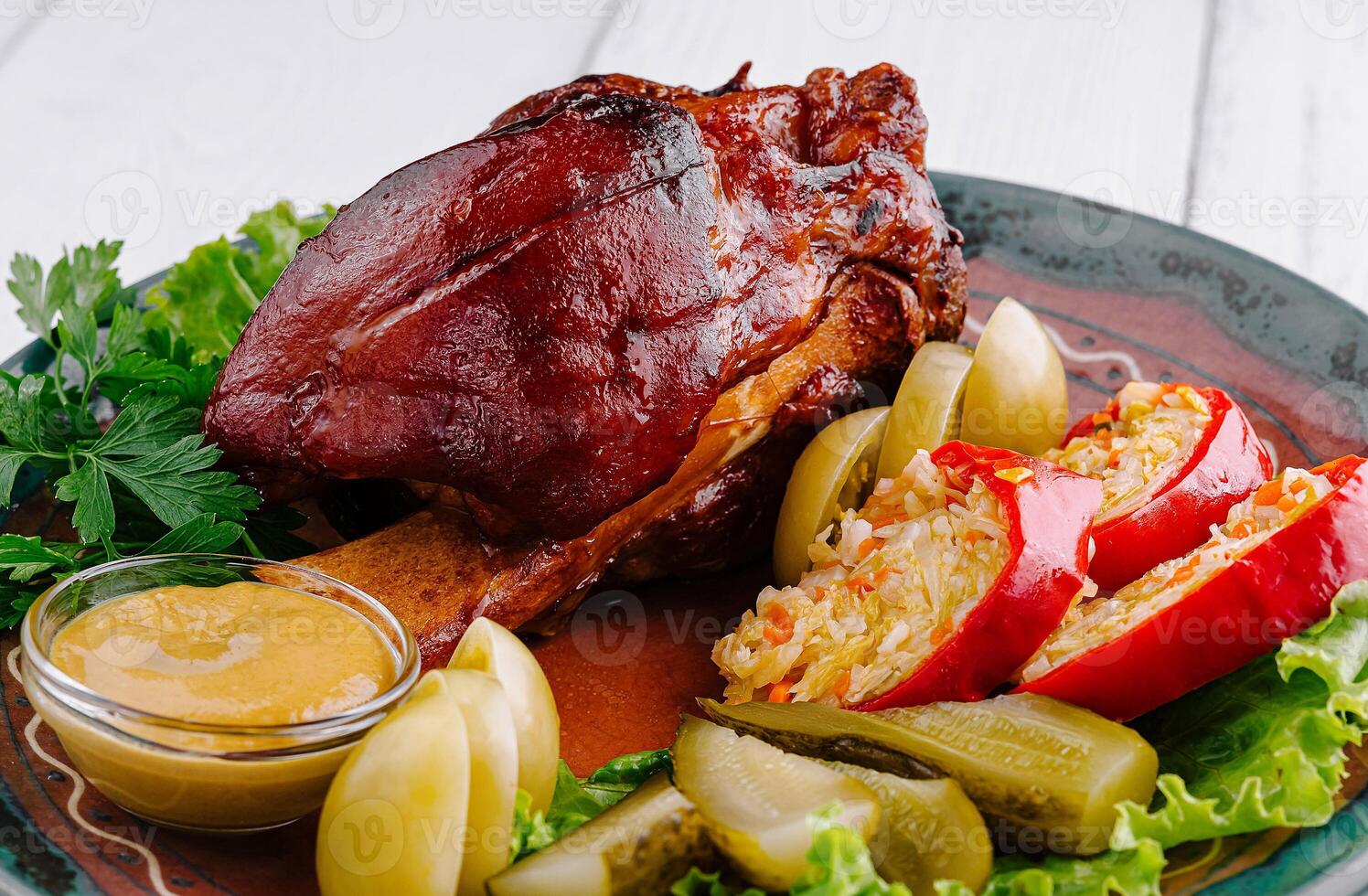 Roasted pork knuckle being served on plate with sauerkraut and mustard photo