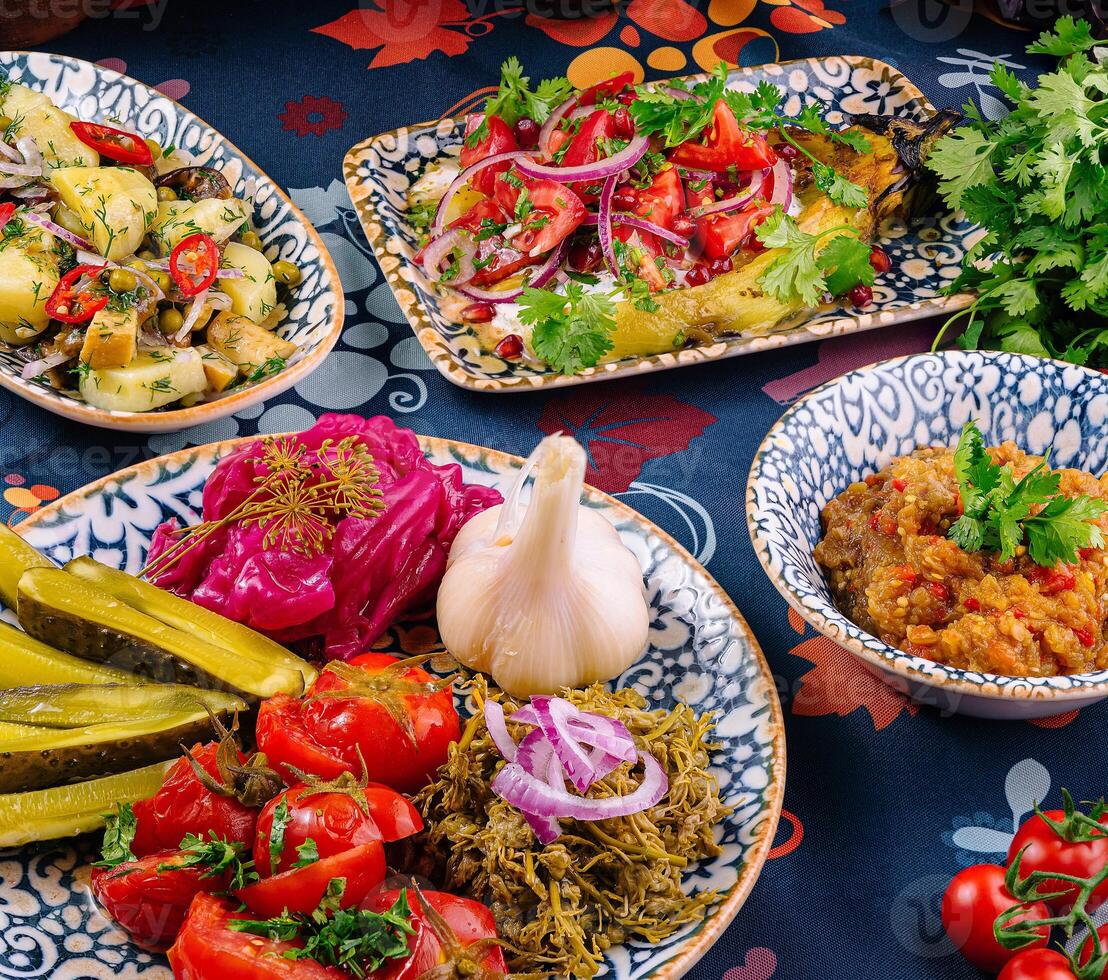 Variety of delicious dishes served on a floral tablecloth photo