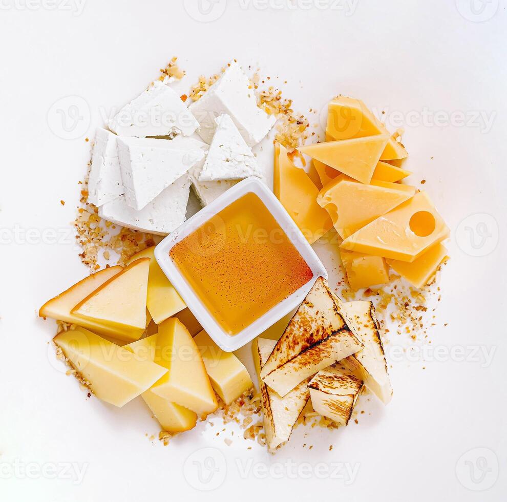 Different types of cheese arranged on plate with honey serving idea photo