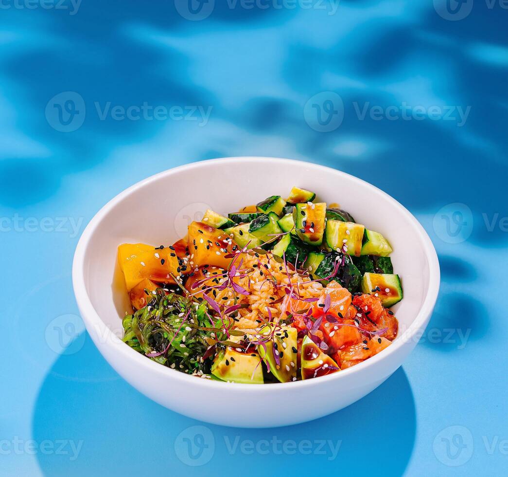White bowl presenting colorful hawaiian style poke bowl with salmon and mango photo