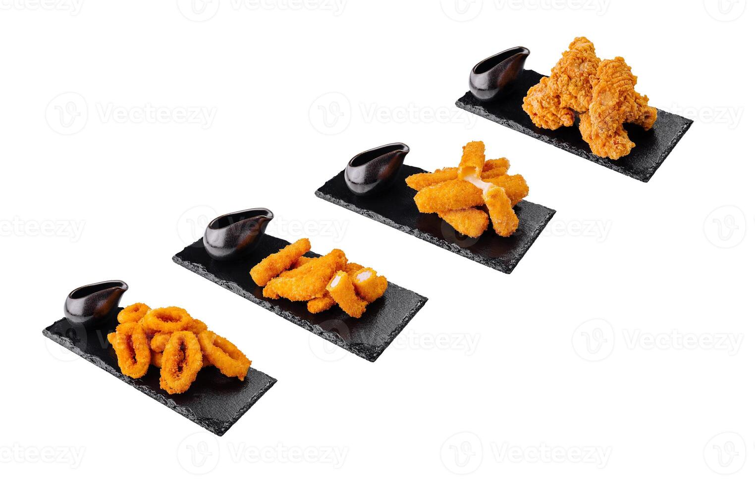Deep fried appetizers served with dipping sauce on black stone platters photo