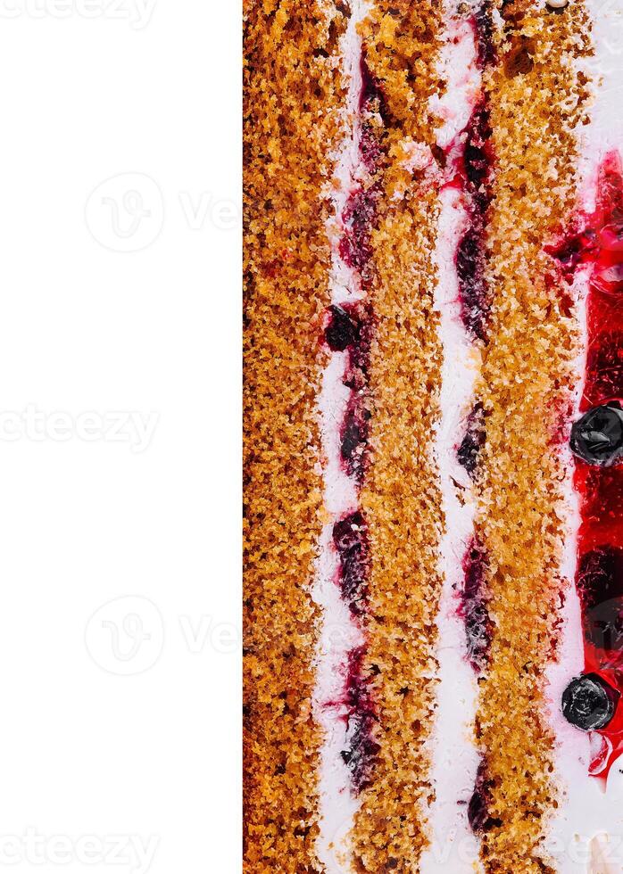 Delicious cake layers showing filling and berries close up photo