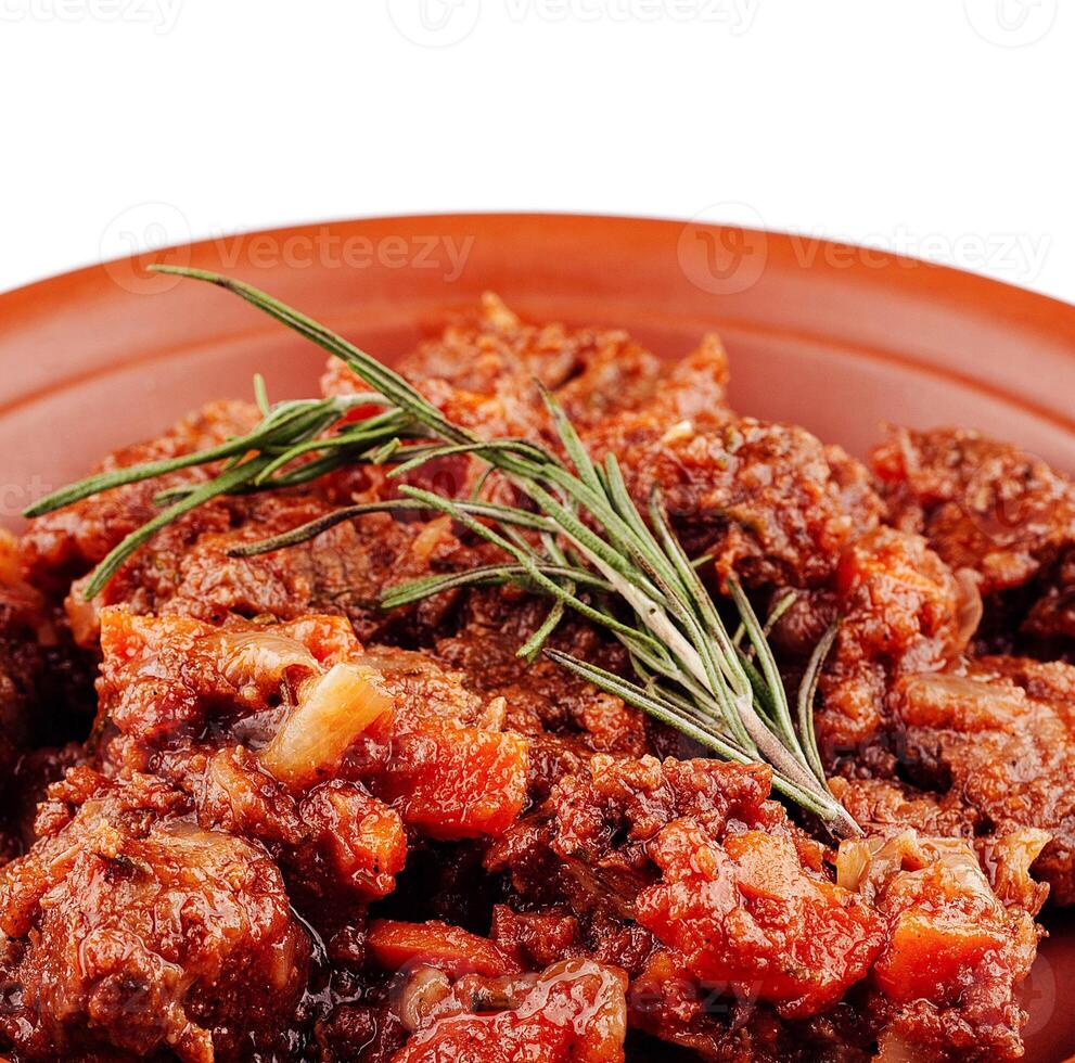 Delicious beef stew with rosemary slowly simmering on plate photo