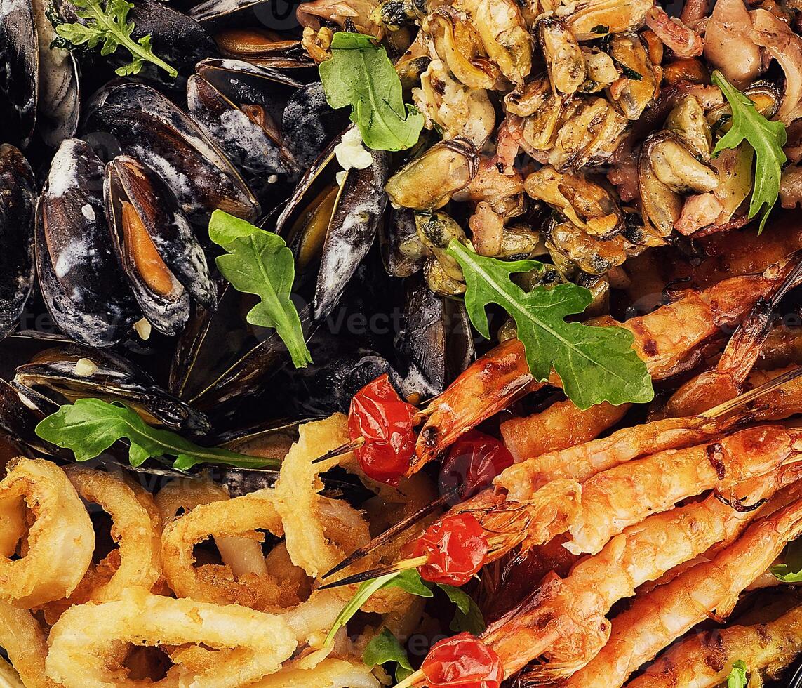 Delicious array of assorted seafood, including prawns, mussels, and calamari photo