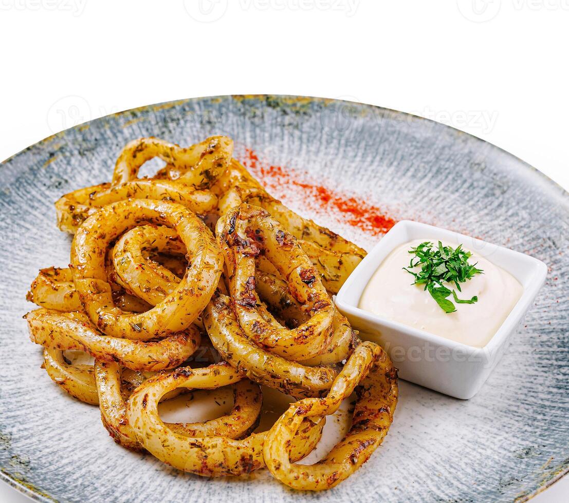 Fried squid rings served with white sauce on elegant restaurant plate photo