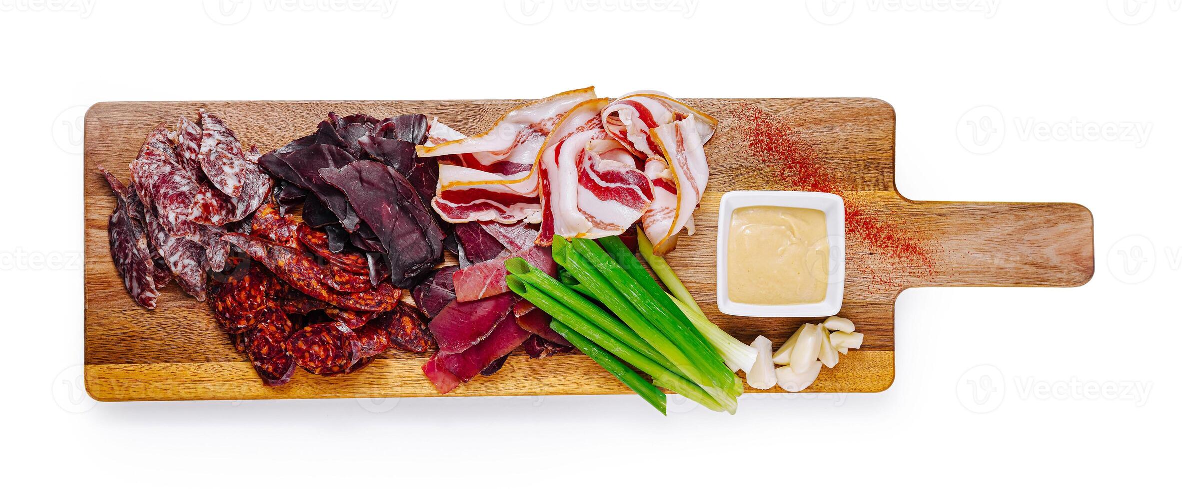 Variety of dried meat snacks lying on wooden cutting board photo