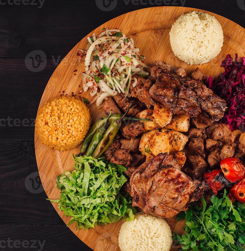 Delicious grilled meat plate served with rice, vegetables and salad photo