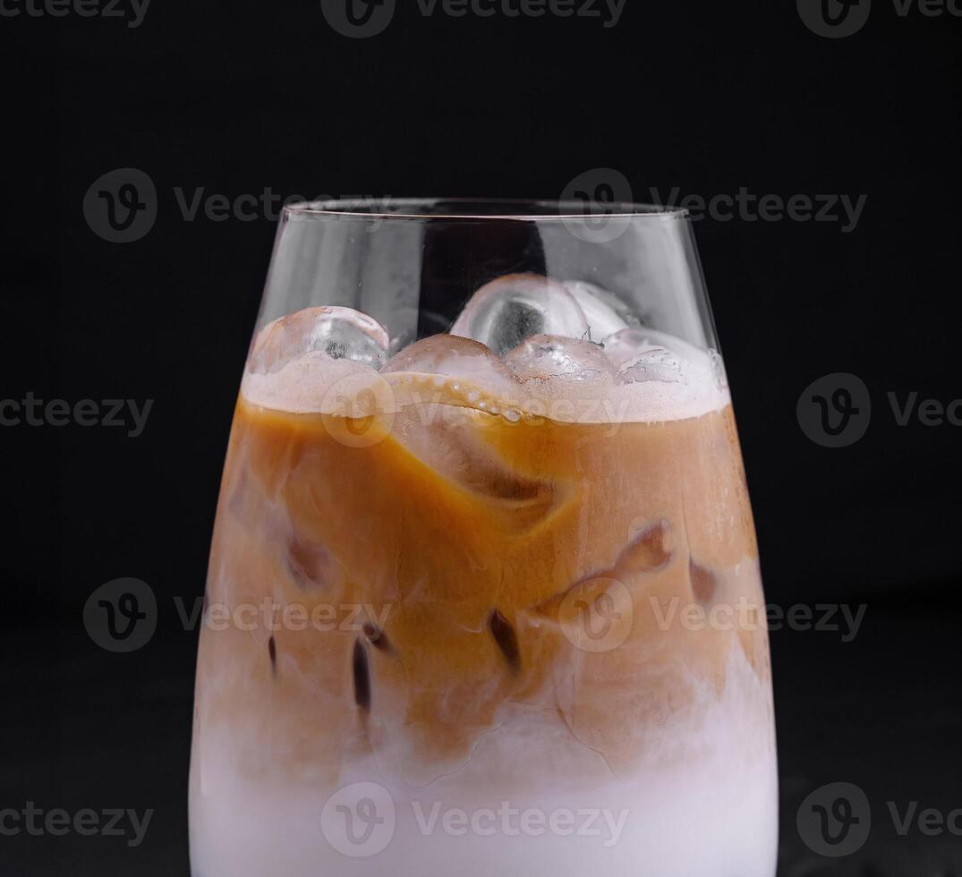 Iced coffee latte with milk and boba tapioca pearls standing on black background photo