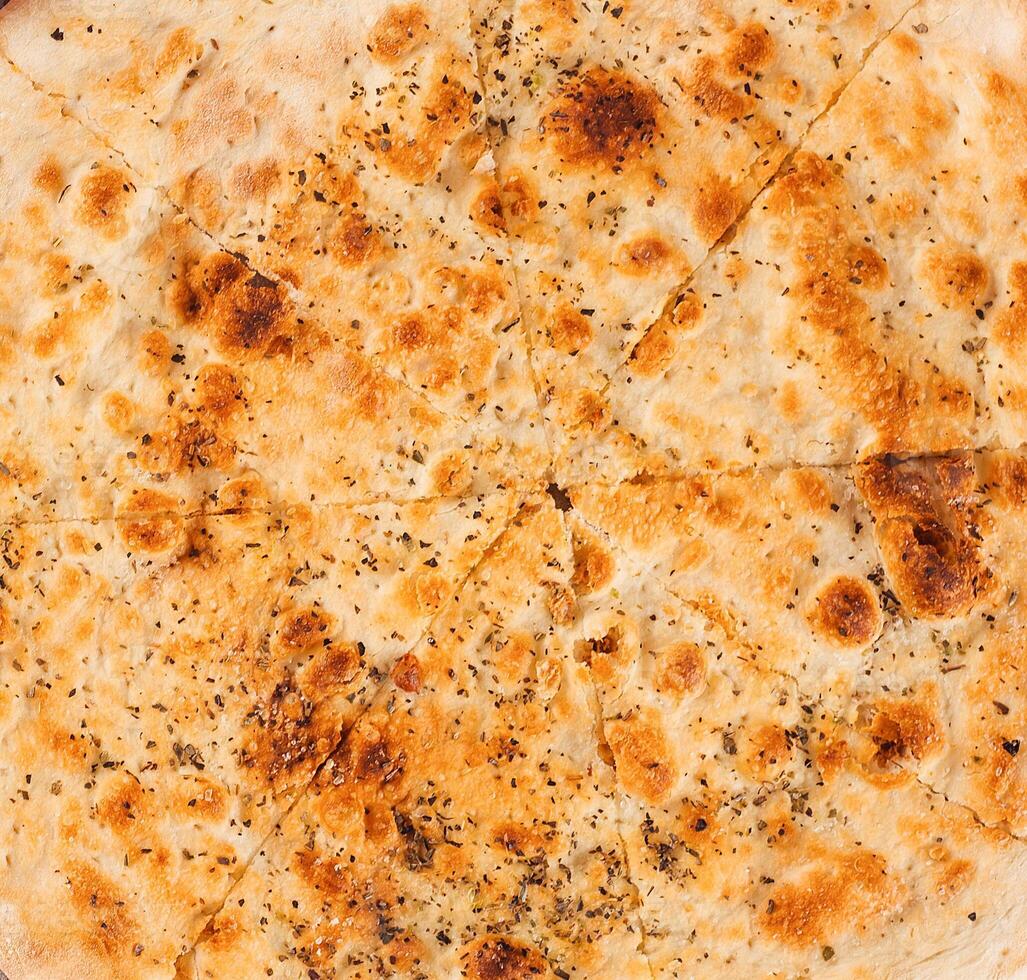 Delicious sliced focaccia bread with herbs and spices close up photo