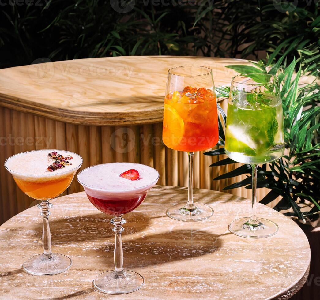 Four colorful cocktails resting on a table in a tropical setting photo
