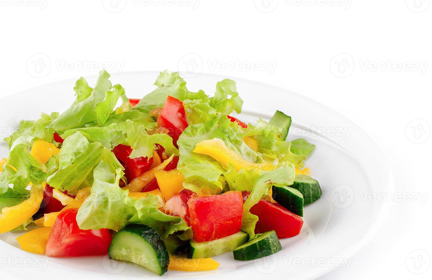 Fresh salad with lettuce, tomatoes, cucumbers and peppers on white plate photo