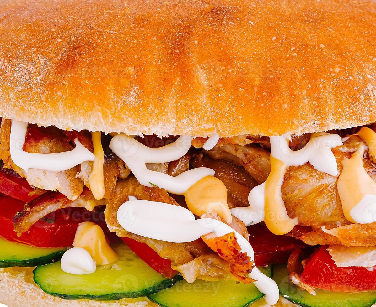 Delicious doner kebab sandwich with fresh vegetables and sauce photo