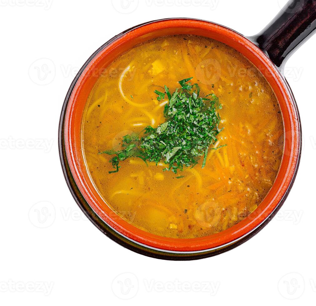 Chicken soup with noodles and carrots being served in a bowl photo
