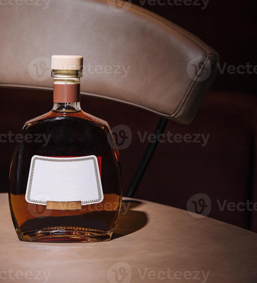 Bottle of cognac resting on a bar table in a nightclub photo