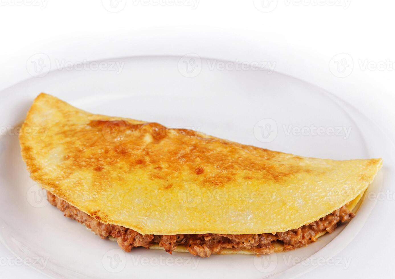 Delicious omelette filled with minced meat lying on a plate photo