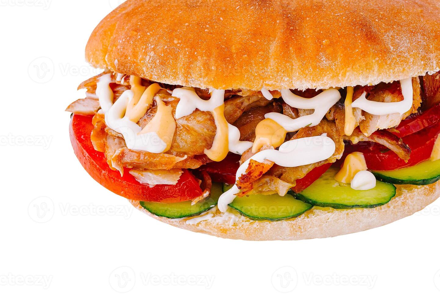 Doner kebab sandwich is lying on a white surface and showing its ingredients photo