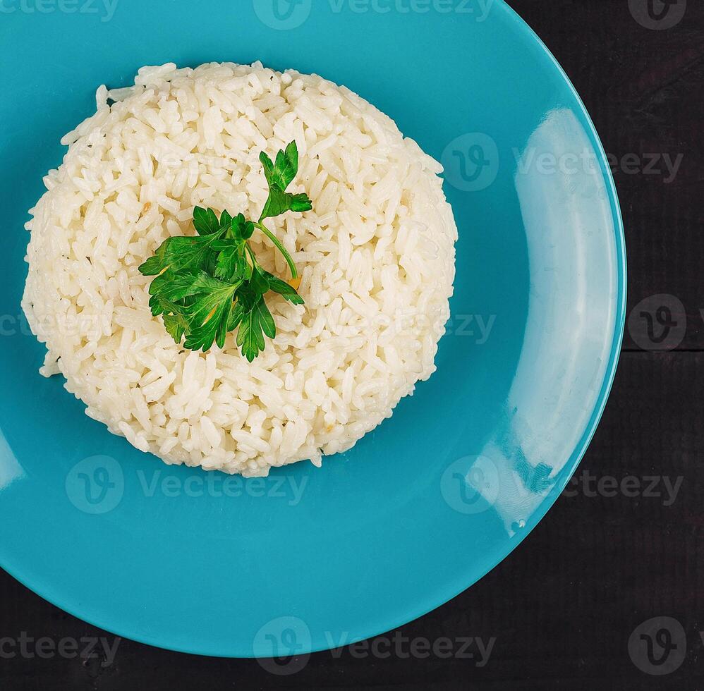Plate of rice on a wooden table with garnish photo