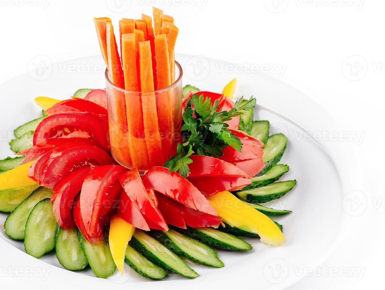 Fresh vegetables arranged on plate forming flower shape with carrots in the middle photo