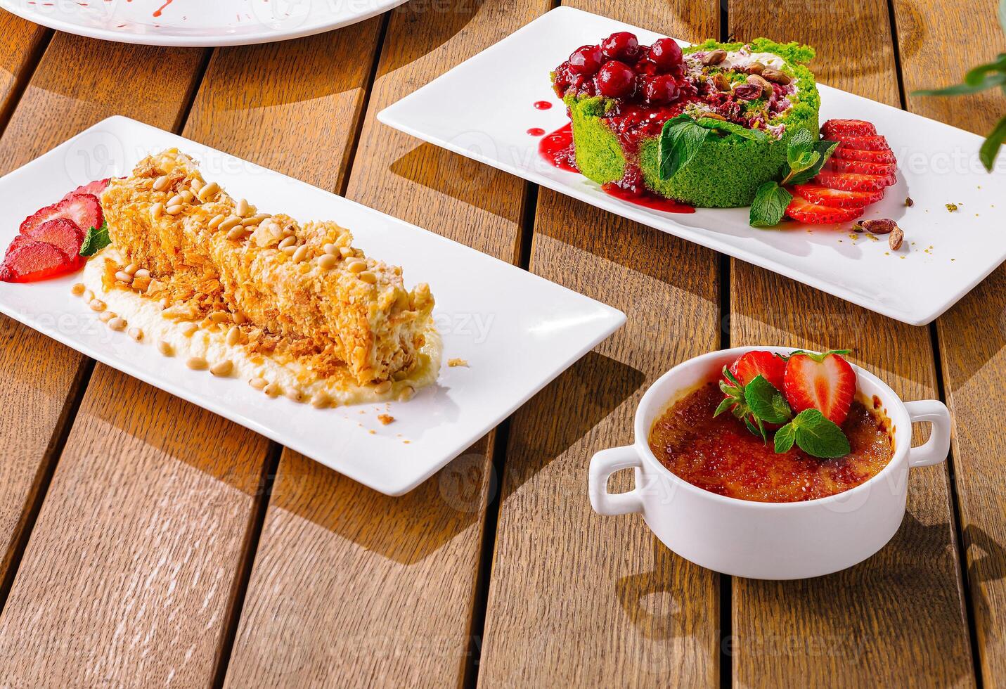 assorted elegant desserts on wooden table photo