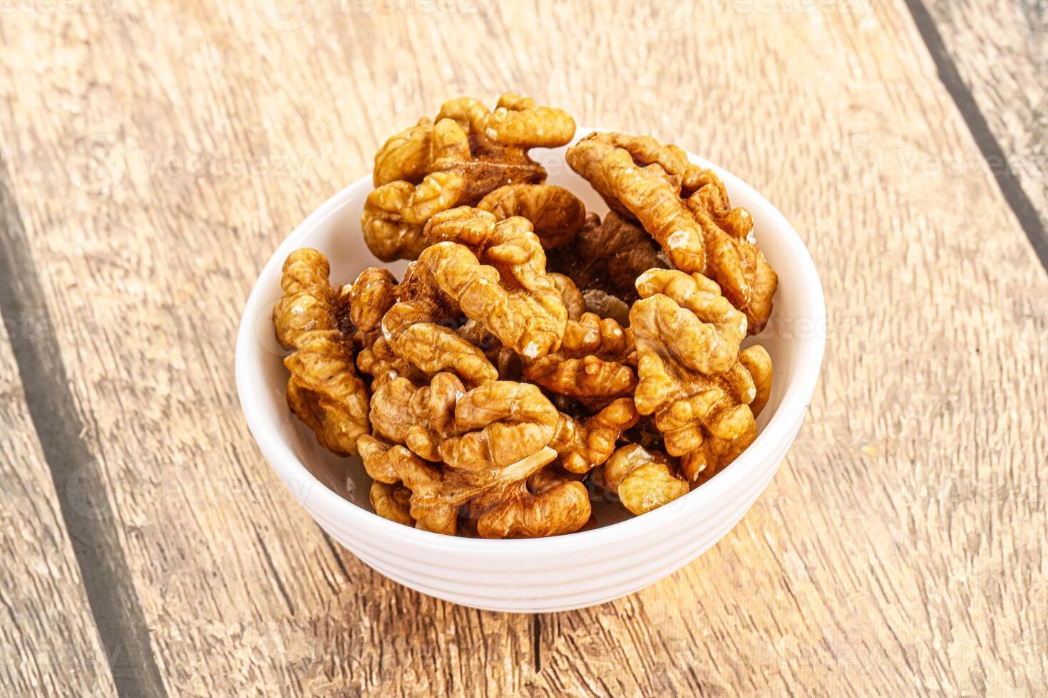 Cracked unshelled walnut in the bowl photo