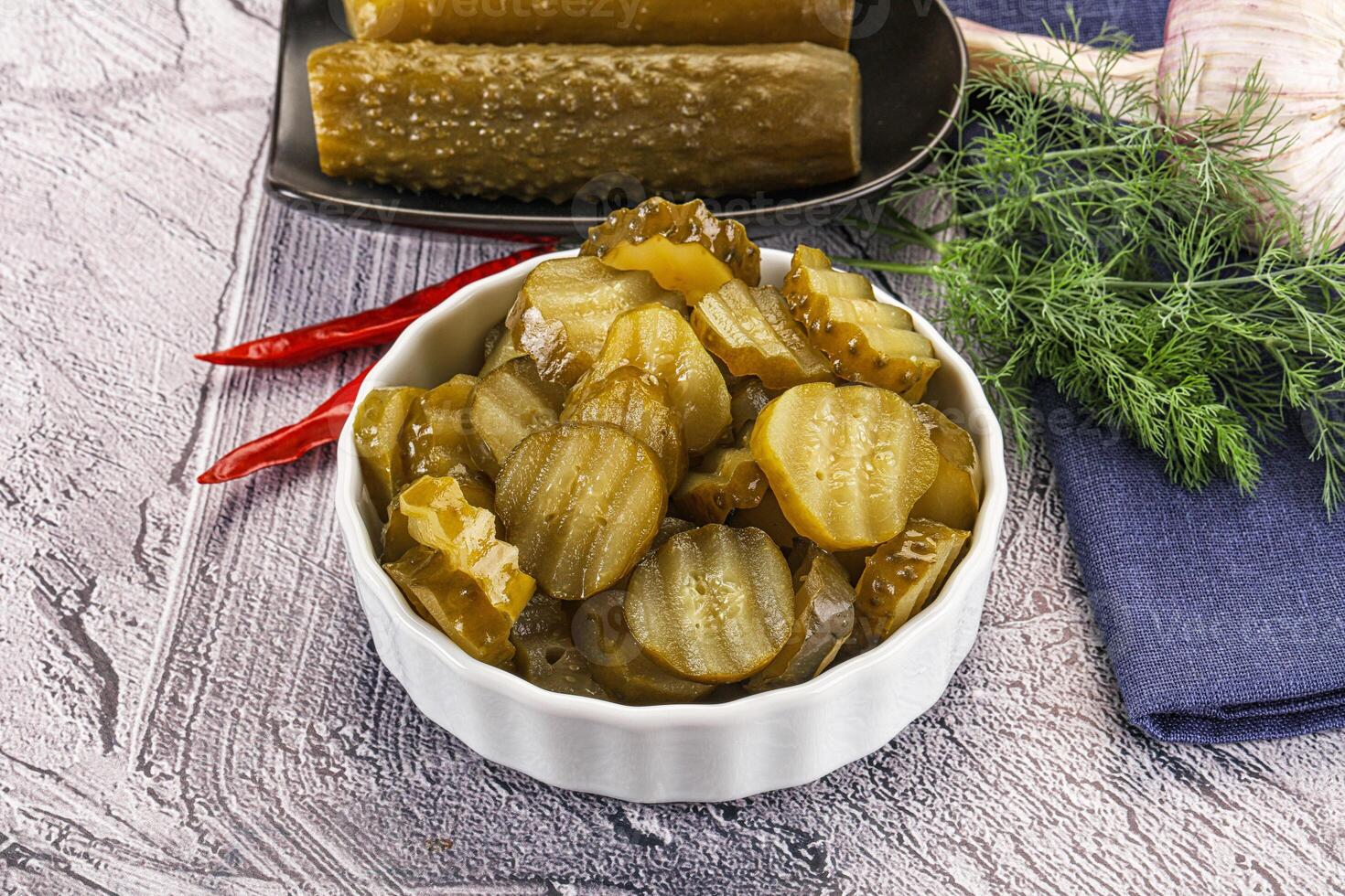 Sliced marinated cucumbers in the bowl photo
