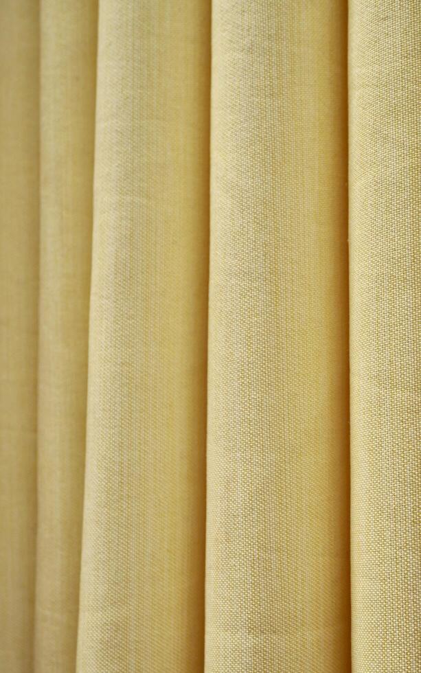 Yellow colored curtain fabric texture isolated on vertical ratio background. photo