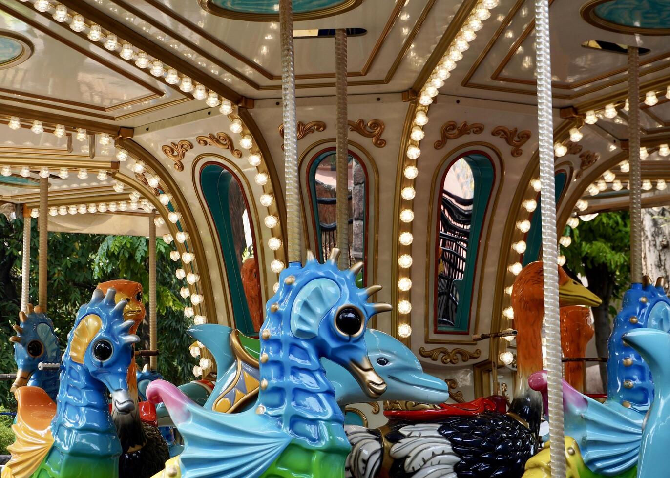 Carousel amusement park toy machine with seahorse and ostrich animal shaped ride isolated on horizontal ratio background. photo