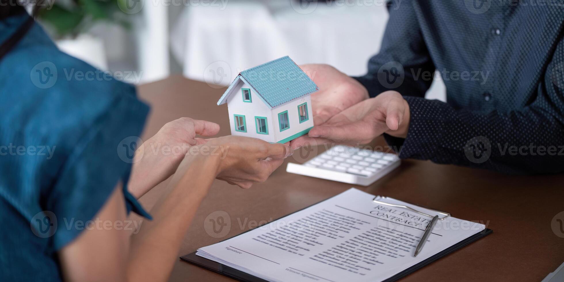 Real Estate Agent Facilitating Home Purchase Agreement with Clients photo