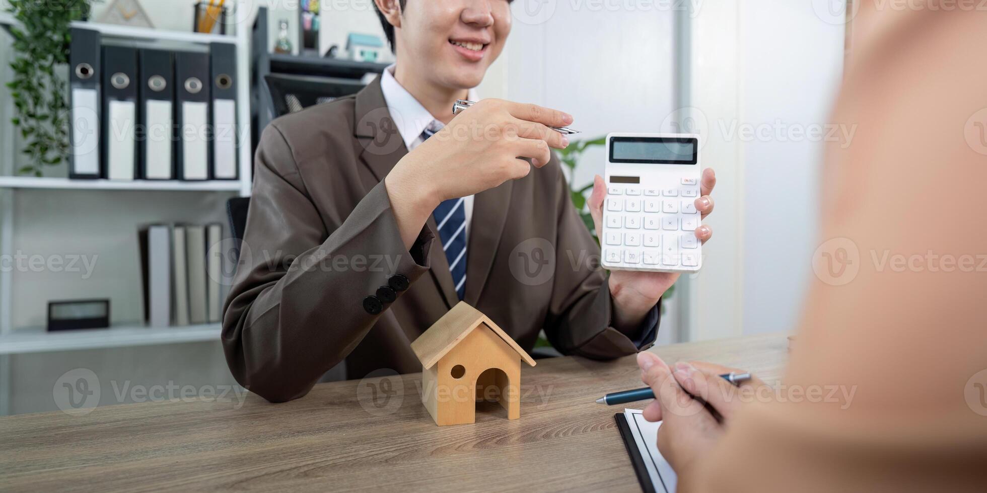 Real Estate Agent Calculating Mortgage Payments with Client for Property Financing Solutions photo