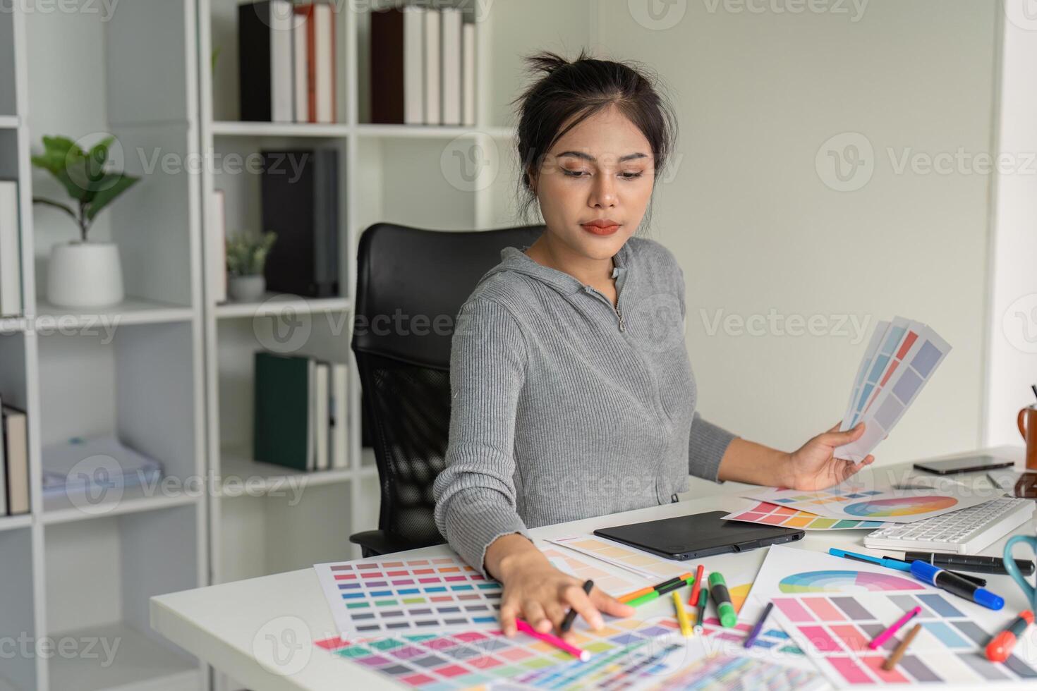 Graphic designer analyzing color swatches at desk photo