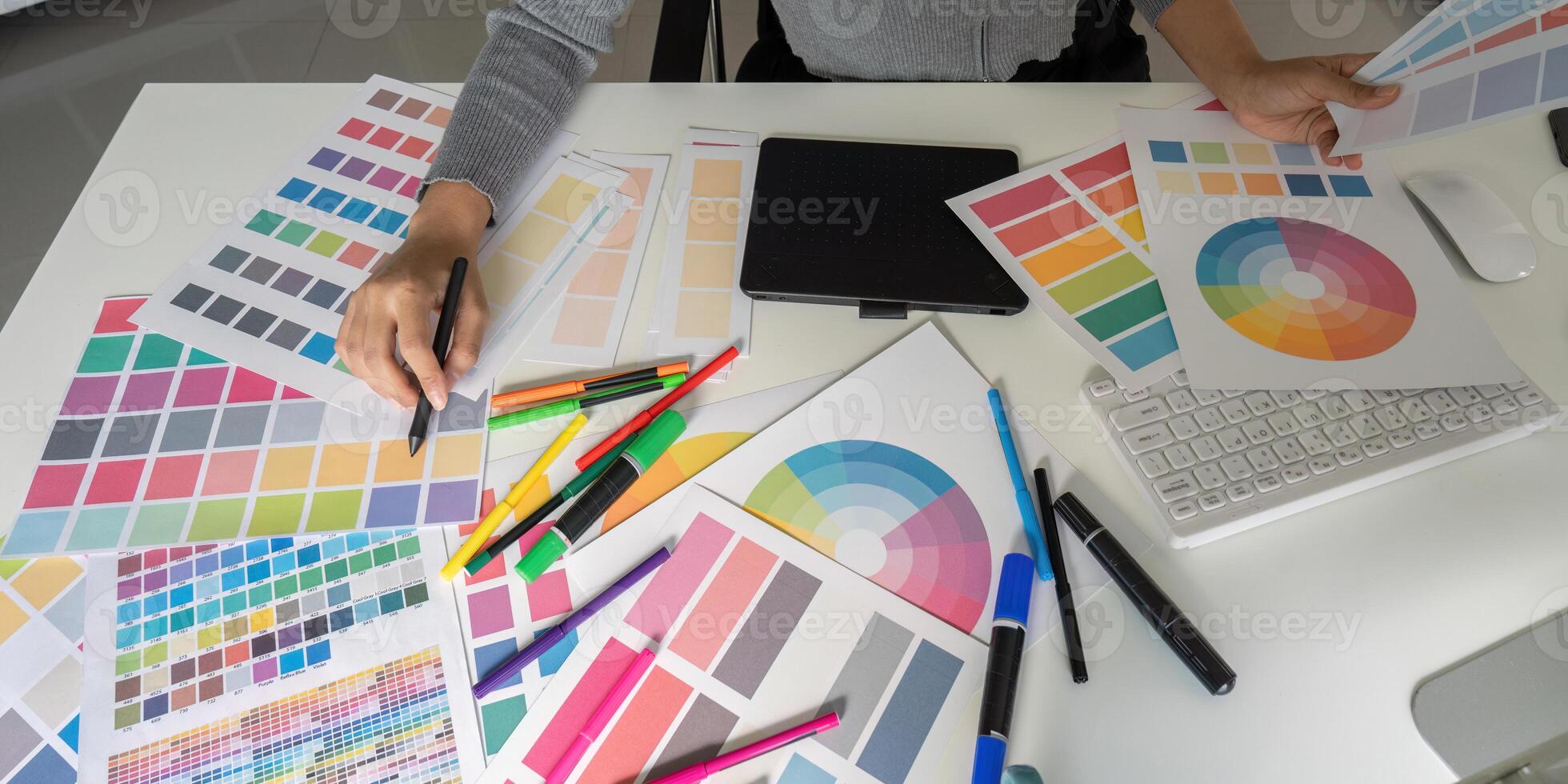Graphic designer organizing color swatches on desk photo