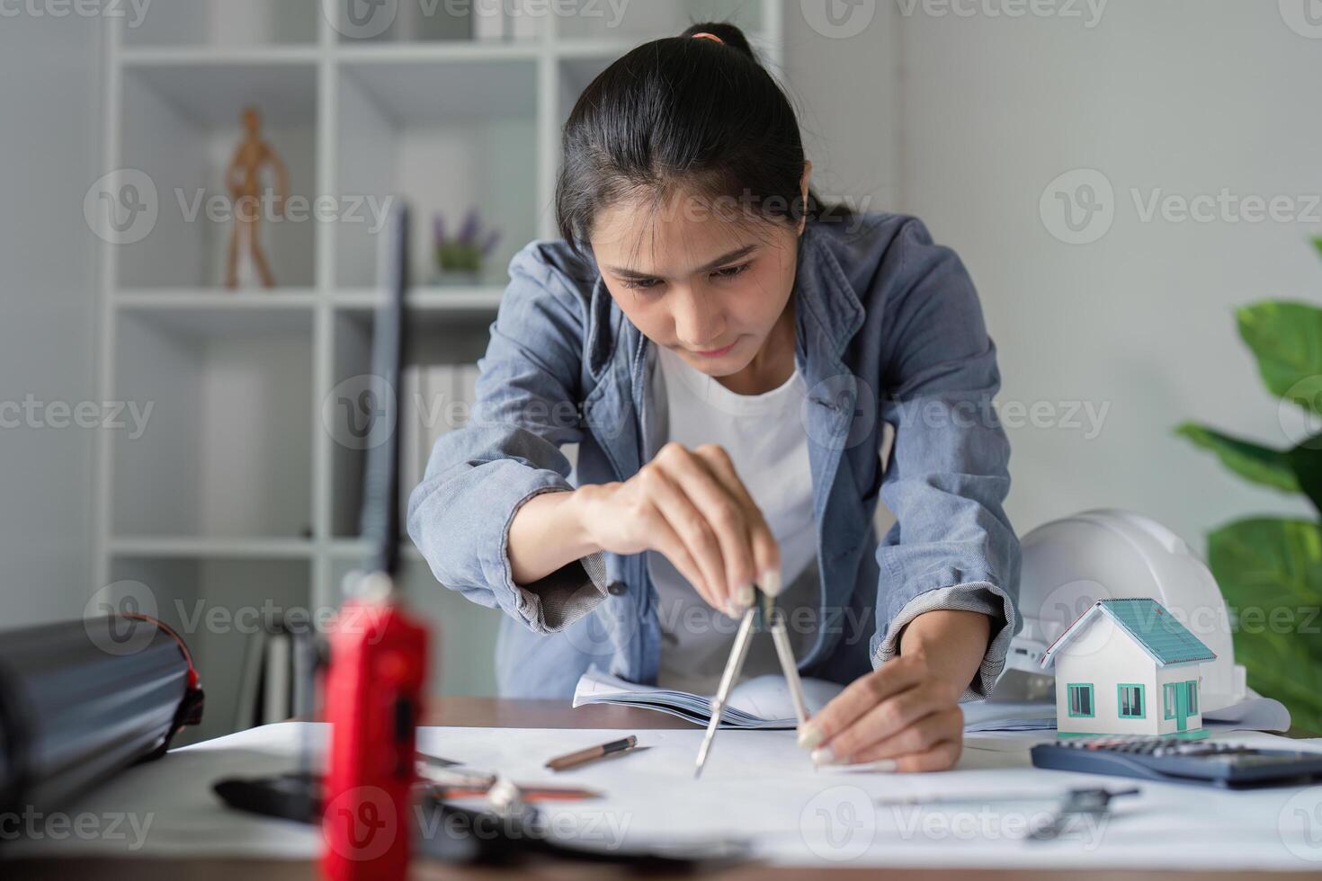 Engineer using compass for architectural drafting in office photo