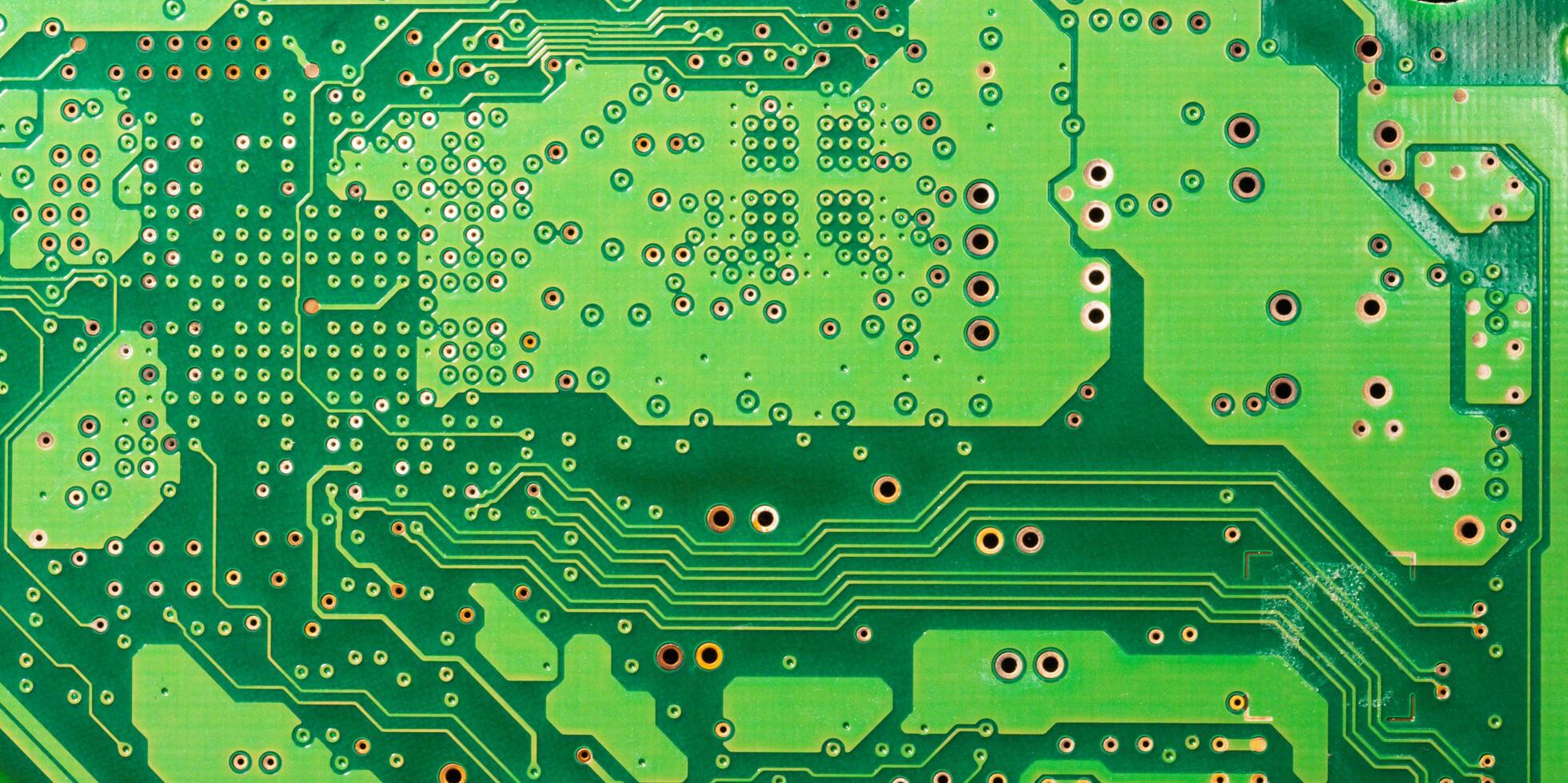 Close-up of a green printed circuit board with electronic components and chips photo